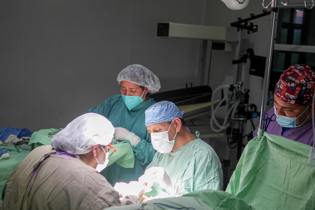 Ein Chirurg und sein Team in OP-Kleidung bei einer Operation im Operationssaal des Hospitals
