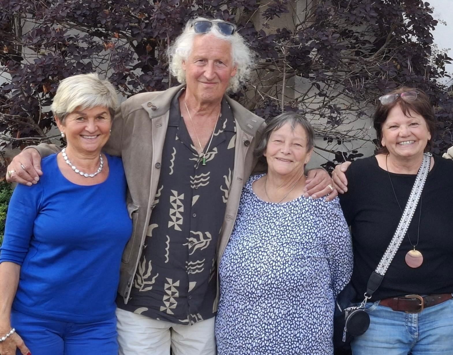 Maria Mayr, Omrael Norbert Muigg, Rosa Theuer und Doris Egger vom Verein Paz Mundo Österreich, Arm in Arm vor einem Strauch